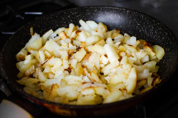 Roasted baby potatoes in iron skillet. Dark grey background.