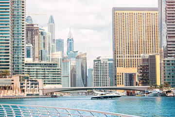 Fototapeta premium Scenic view of a Dubai Marina district with sea harbour and skyscrapers. Development and real estate investment