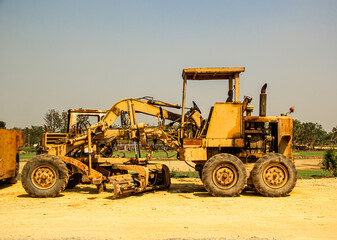 Grader leveling gravel on road