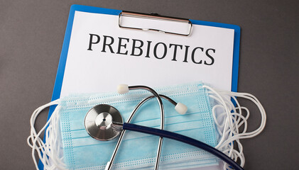 Folder with paper text PREBIOTICS , on a table with a stethoscope and medical masks, medical...