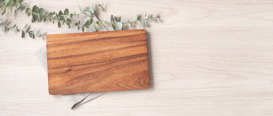 Wood cutting board on linen napkin on wooden background - obrazy, fototapety, plakaty