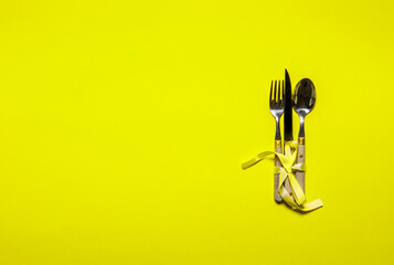 Cutlery set on yellow paper with copy space