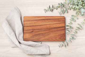 Wood cutting board with linen napkin and plant