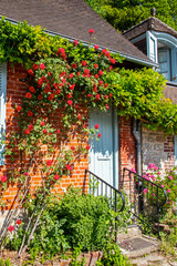 Gerberoy, Façade de maison couverte de roses dans une rue piétonne du village. Oise. Picardie....
