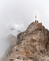 mountaineers next to the famous gipfelkreuz on Zugspitze, top of Germany, with Jubileumsgrat in the...