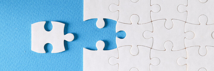 Last piece of puzzle lying separately on blue background