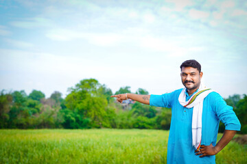Happy young indian farmer showing hand at sugarcane field (1)