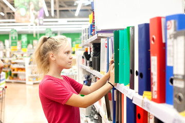  Young female student choosing office supplies