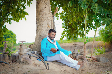 indian farmer sitting comfortably at field