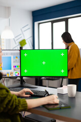 Photo artist retoucher editing assets in digital retouching program working in production agency studio. Photographer woman looking in computer with green screen, chroma key mockup isolated display.