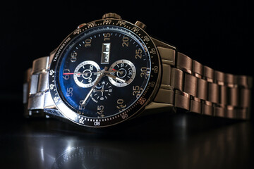 Luxury quartz chronograph watch on a black background, close-up