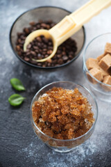 Glass container with coffee granita over dark grey stone background, vertical shot, selective focus