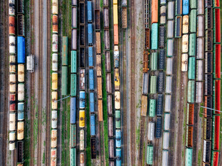 Aerial photo of railway lines. Freight wagons with goods on railroad station. Cargo transportation....