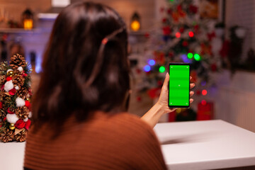 Festive person holding smartphone with green screen for modern technology on mockup template....