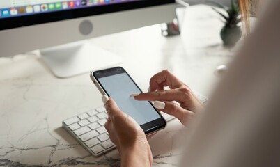 Close up Woman hand Using a Smart Phone with blank screen at modern office