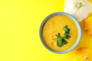 Concept of tasty food with pumpkin soup on yellow background