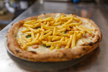 Pizza napoletana con patatine fritte, würstel, basilico e provola