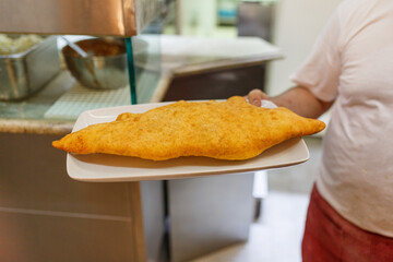 Pizza fritta classica napoletana ripiena di ricotta, ciccioli croccanti e pepe