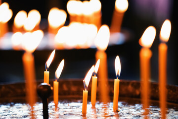Light of many burning candles in the church. Horizontal image.