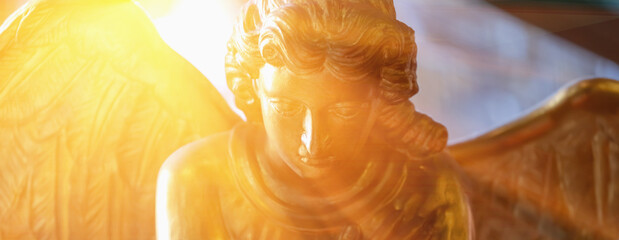 Gold angel. Fragment of an antique statue. Horizontal image.