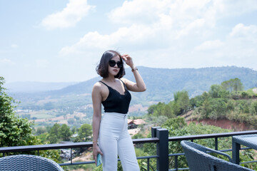 A smart woman short hair in soft dress and white short pants on cafe hight hill, she is happy and...