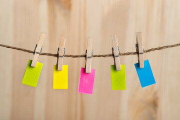 Small multicolored notes hang with clothespins on rope. Copy space. Place for your text. Note, reminder