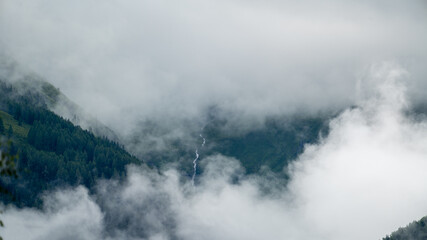 low hanging clouds in the mountains at a summer day