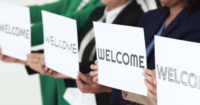 Group of businesspeople joins together greeting and hold welcome words for a sign of happiness and pleasure for coming of something or someone. Good teamwork in office concept.  