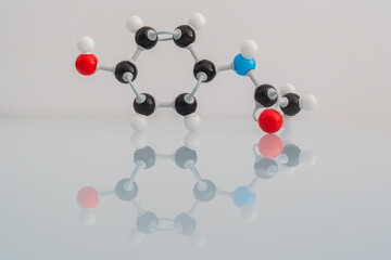 Picture of an isolated molecular model of paracetamol with its reflection on a table