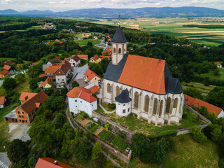 Fototapeta na wymiar Ptujska Gora Church on Hill Top in Slovenia Countrtyside. Drone Scenic View