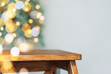 Wooden stepladder against the background of blurry christmas lights.