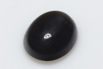 Natural stone scapolite cat's eye on a white background