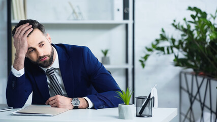 sad businessman in suit sitting in office