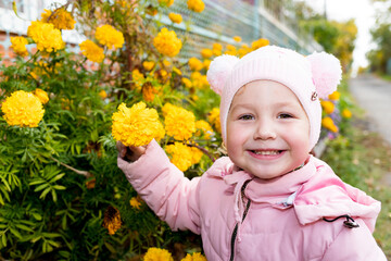 child sniffs yellow flowers. scent of flowers