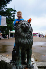 Batumi, Georgia - June 30, 2021: Boy on lion sculpture