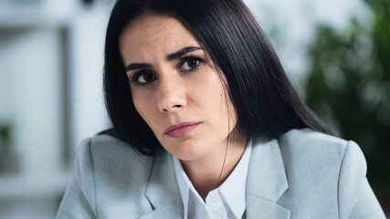 displeased businesswoman looking at camera in office