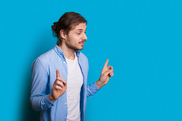 Man with beard point in hipster style on blue background. Handsome man. Hand gesture.