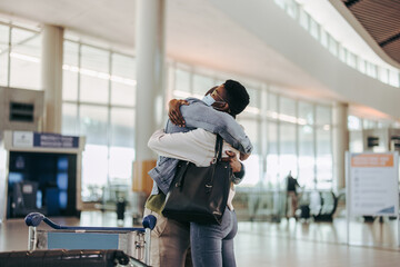 Wife giving good bye hug to her husband at airport