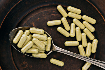 quercetin supplement capsules  on iron spoon. immune prevention care concept. selective focus photo