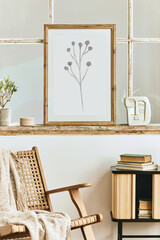 Modern composition of living room interior with design armchair, wooden shelf, old window, dried flowers in vase, brown mock up poster frame, decoration and elegant personal accessories. Template.