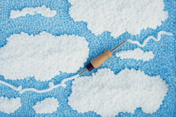 View of a punch needle with a white velour thread on the background of embroidery project in white...