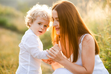 Happy woman holding her son by the hand in nature