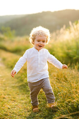 Cheerful boy runs across the summer field