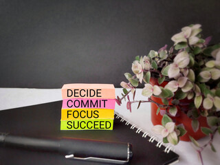 Inspirational and Motivational Concept - DECIDE COMMIT FOCUS SUCCEED text on colourful paper background. Stock photo.