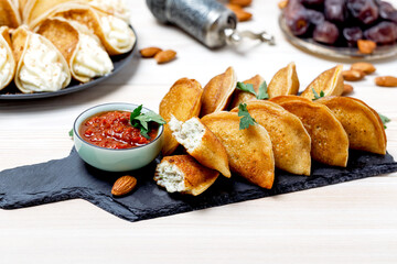 Qatayef Staffing Chicken With Dip Sauce Harissa On Black Board On Wooden Background. Side View.