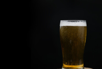 Glass Of Bear On Wooden Board Black Background. Side View. Low Key. Copy Space.