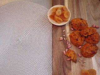 the process of making carrot cookies with the addition of dried apricots, peanuts and sunflower seeds on a silver background. High quality photo