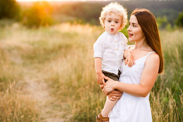 Portrait of a mother with a cute son in her arms in nature