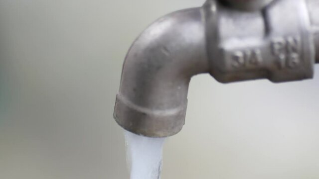 Close-up video of faucet with running water, water, and energy saving concept.