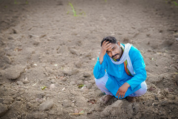 Indian poor farmer troubled by soil defect, sad farmer in the field